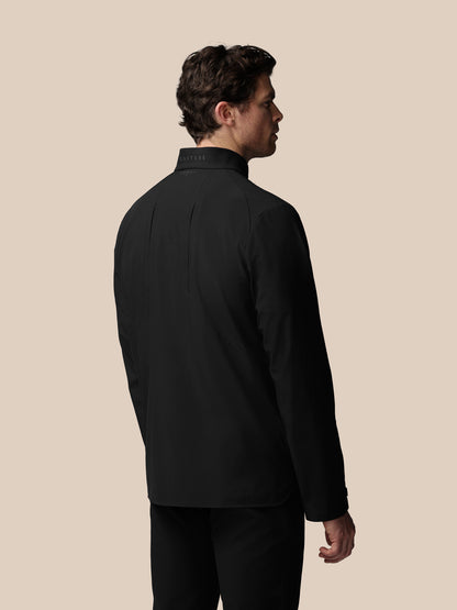 Man wearing a black jacket on a beige background