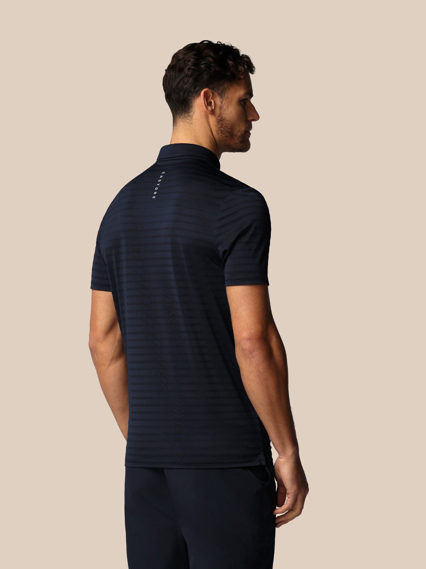 Man wearing a black athletic outfit on a beige background