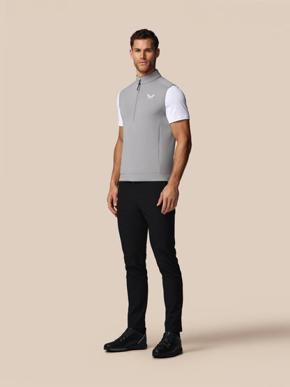 Man wearing a gray and white athletic outfit on a beige background