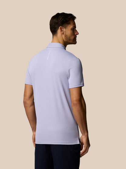 Man wearing a light purple polo shirt on a beige background