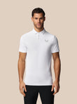 Man wearing a white polo shirt with a Castore logo on a beige background