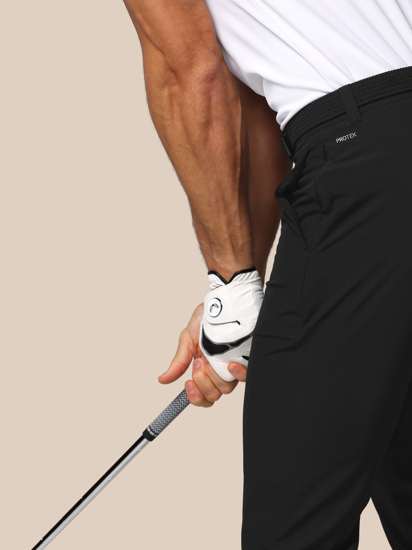 Person holding a golf club with a white glove on a beige background