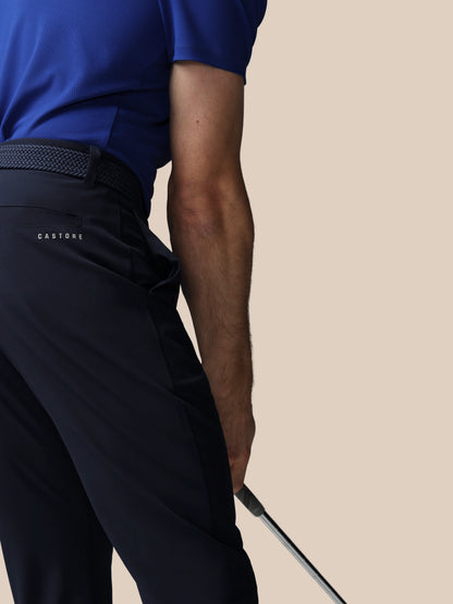 Person wearing navy pants with 'Castore' branding on a beige background