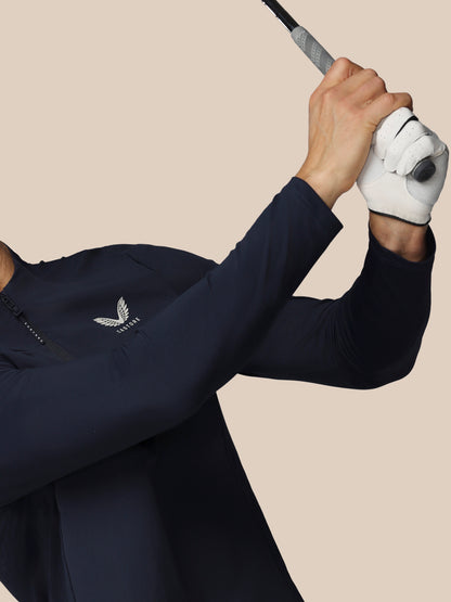 Person in navy blue golf outfit with white glove holding a golf club on a beige background