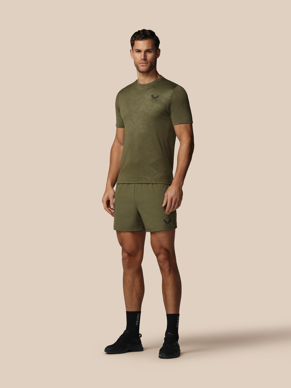 Man wearing a green athletic outfit on a beige background
