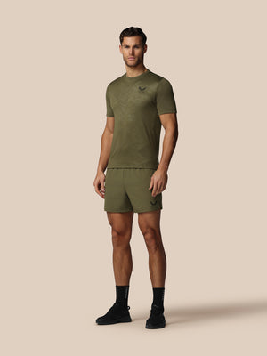 Man wearing a green athletic outfit on a beige background
