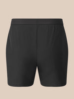 Black athletic shorts with a wide elastic waistband, shown flat against a solid beige background.