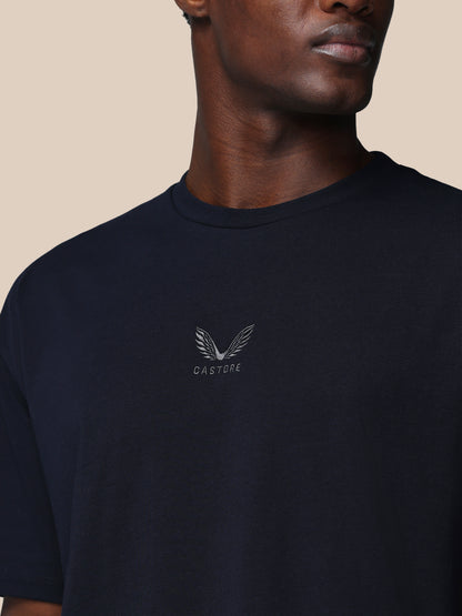 Man wearing a black t-shirt with a logo and text on a beige background