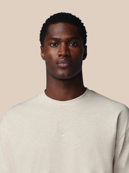 Man wearing a light gray sweater against a beige background