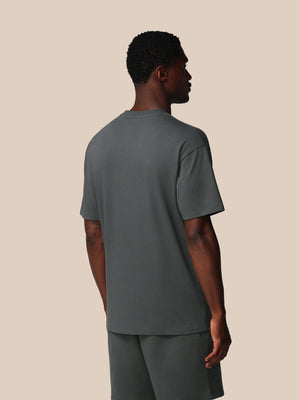 Man wearing a gray t-shirt and pants on a beige background