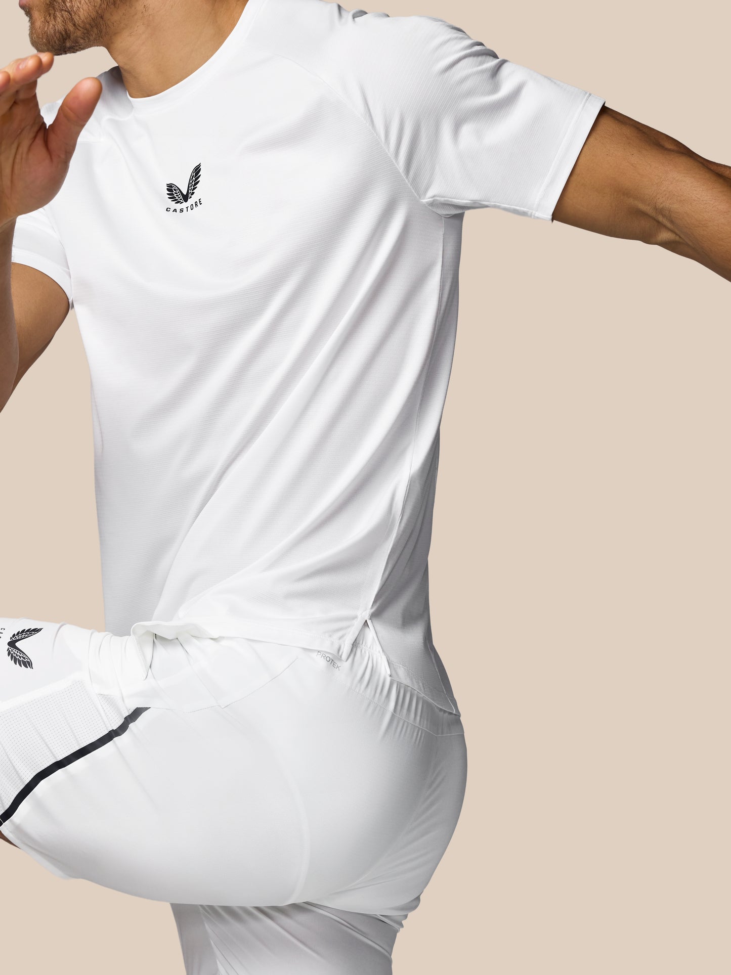 Person wearing a white t-shirt with a logo on a beige background