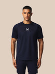 Man wearing a navy athletic outfit with a logo on a beige background