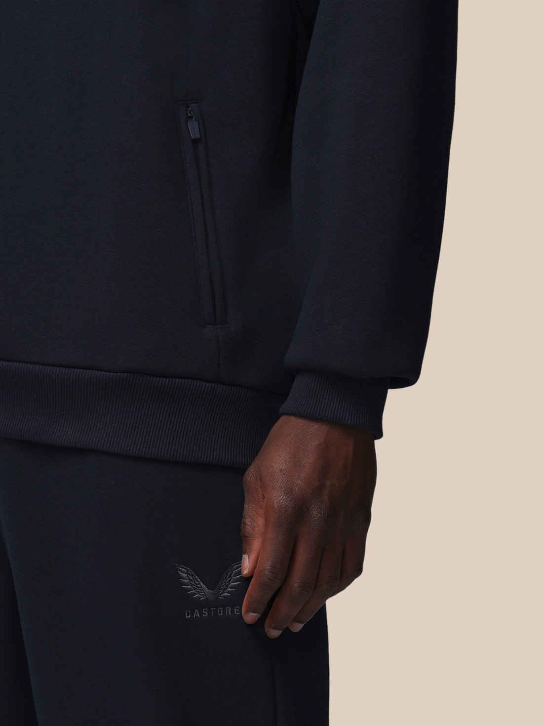 Black hoodie with a brand logo on a beige background