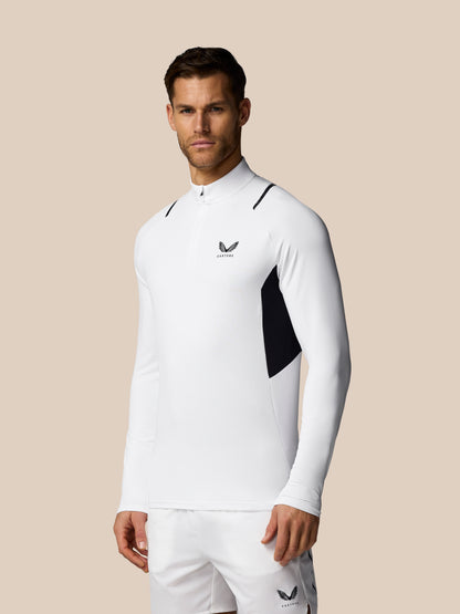 Man wearing a white athletic outfit with a logo on a beige background