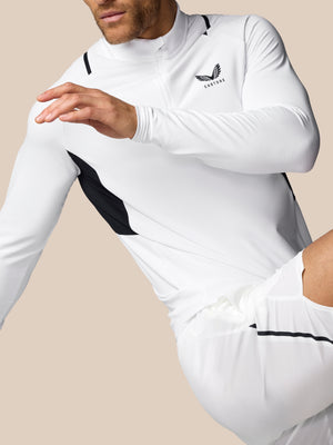 Person wearing a white athletic outfit with black accents on a beige background