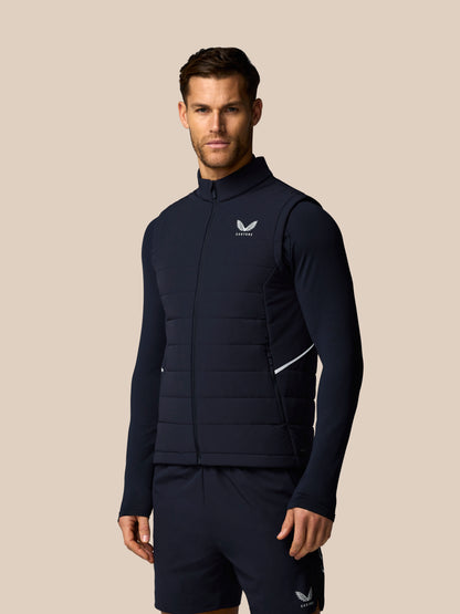 Man wearing a navy blue athletic outfit with a logo on a beige background