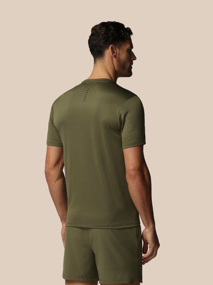 Man wearing an olive green athletic outfit on a beige background