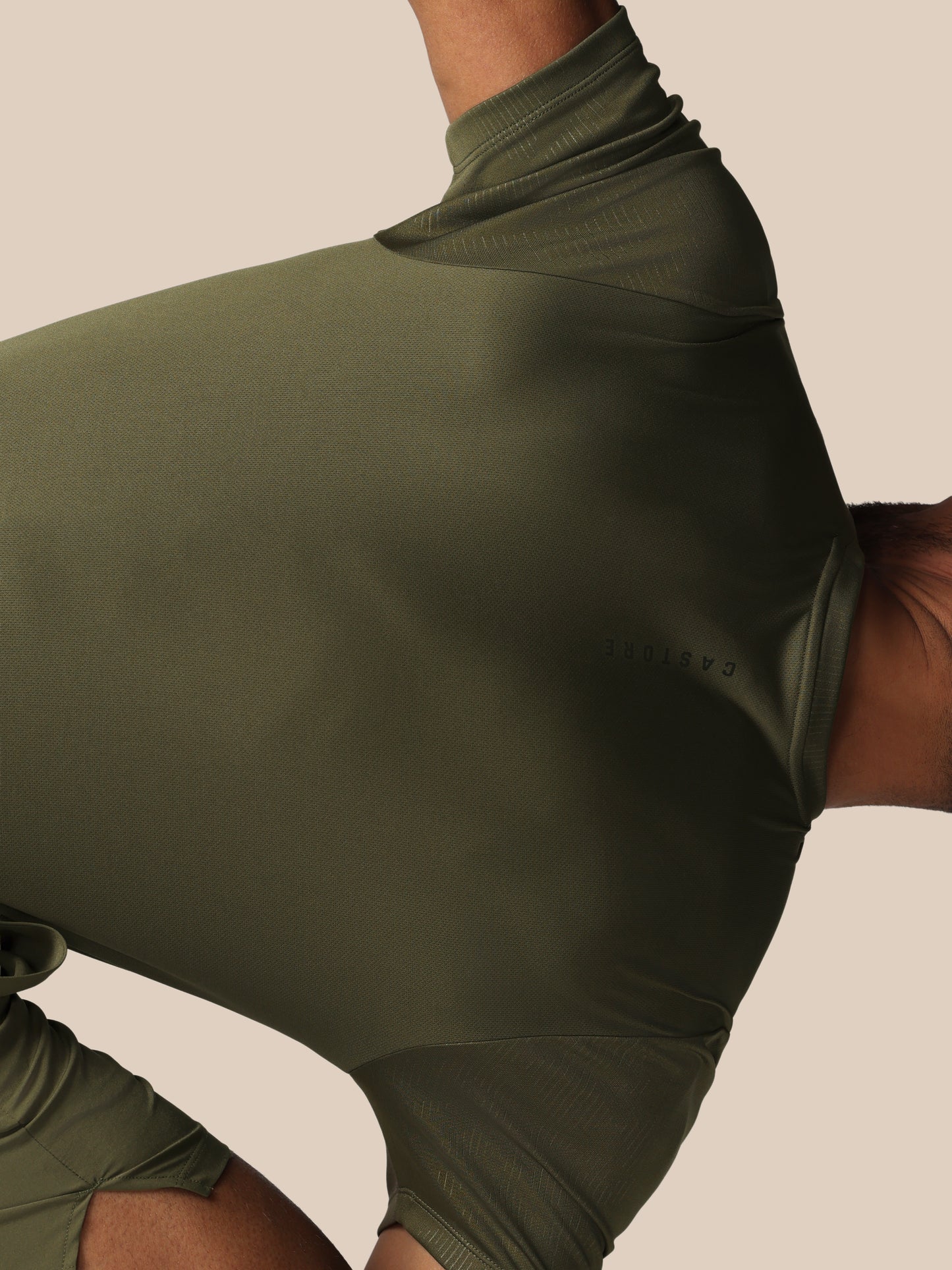 Green athletic outfit with a high neckline on a neutral background