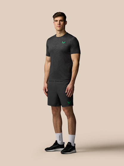 Man wearing a black athletic outfit with a logo on a beige background