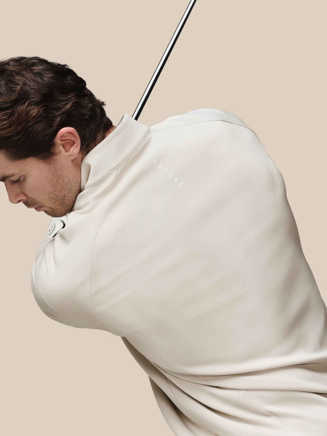 Man wearing a beige quarter zip against a beige background