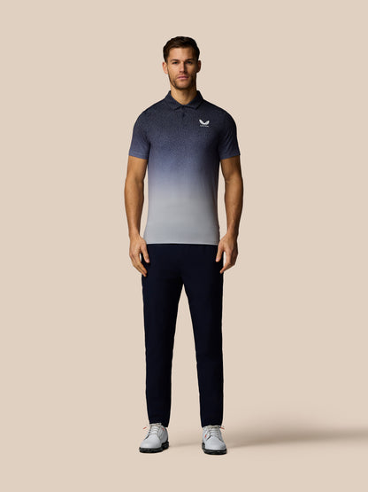 Man wearing a gradient polo shirt and dark pants on a beige background