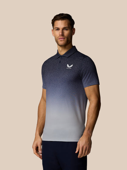 Man wearing a blue and gray gradient polo shirt with a logo on a beige background