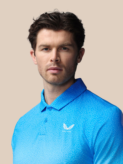 Man wearing a blue polo shirt with a logo on a beige background