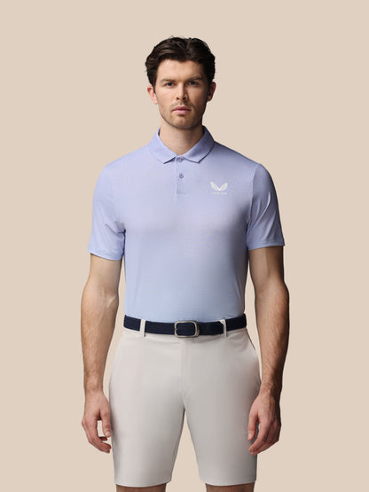 Man wearing a light purple polo shirt and beige shorts on a beige background