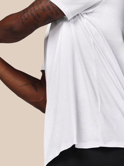 Person wearing a white shirt with a beige background