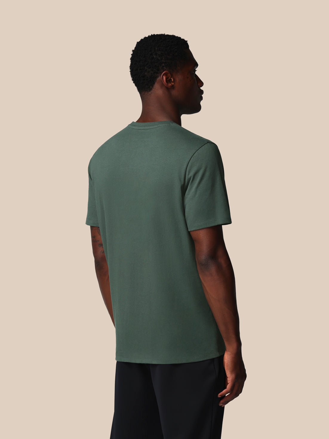 Man wearing a green t-shirt against a beige background