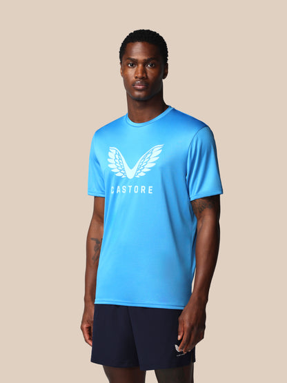 Man wearing a blue athletic shirt with a logo on a beige background