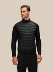 Male model wearing a black Reiss x Castore hybrid jacket with quilted front panels and a stand-up collar.