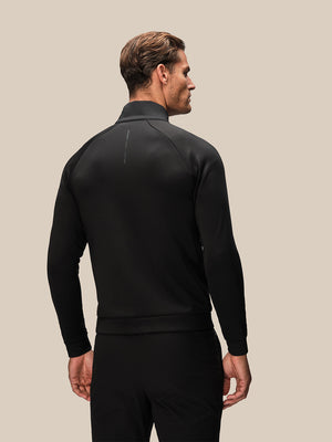 Back view of black Reiss x Castore jacket on a male model with a clean back and subtle vertical branding near the neck