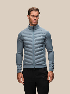 Model wearing light blue Reiss x Castore Hybrid Jacket with quilted front panels and full zip