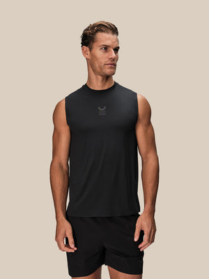 Male model wearing black Reiss x Castore performance vest showing small logo on chest against beige background