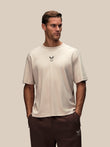 Man wearing a stone graphic short sleeve t shirt with a small chest logo.