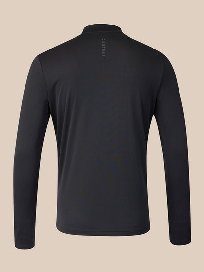 A black long-sleeve quarter-zip athletic top shown from the back, featuring a small vertical 'CASTORE' logo near the collar, set against a solid beige background.