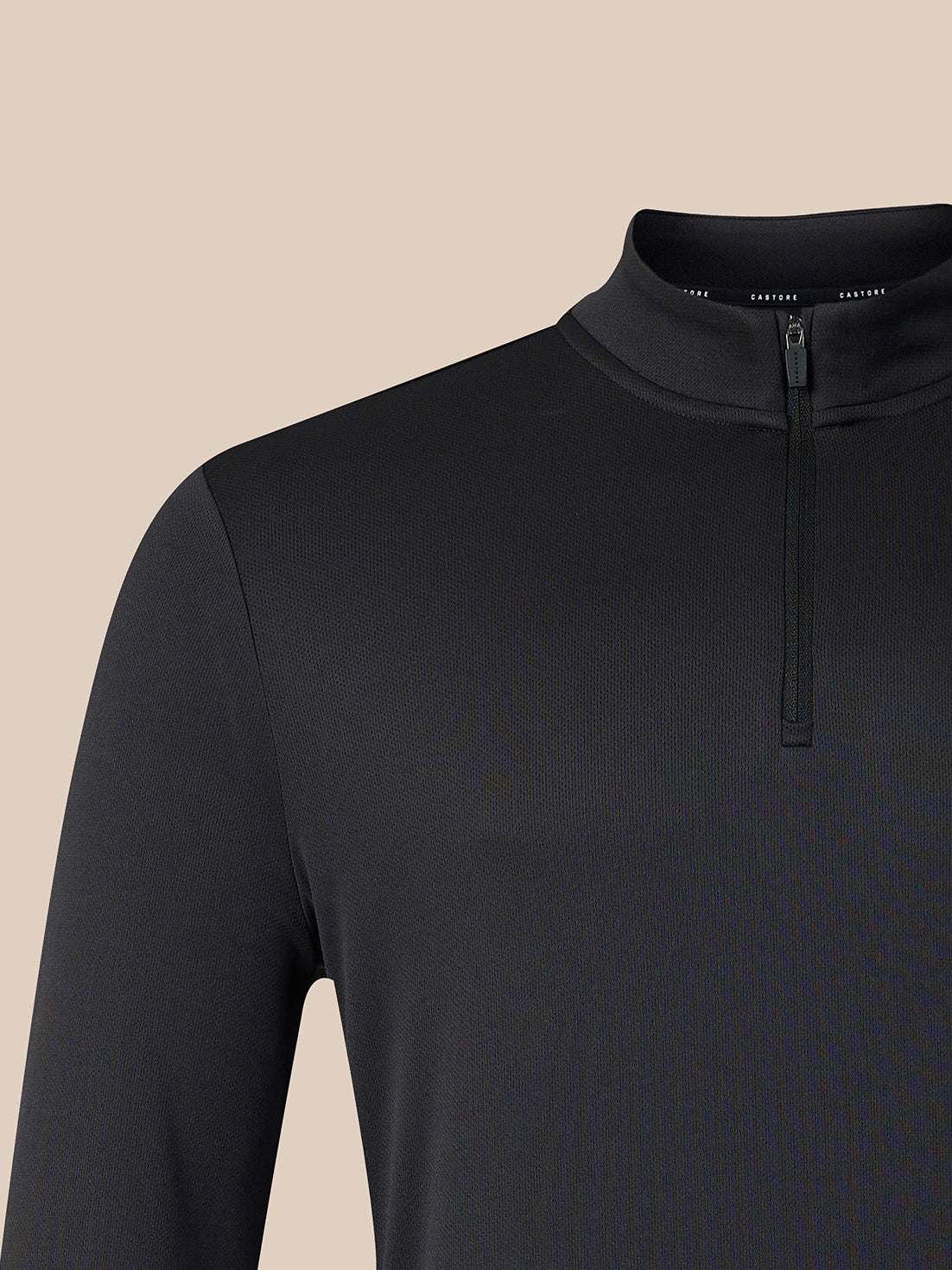 A close-up of a black long-sleeve quarter-zip pullover sweater on a mannequin, showing the collar and zipper against a solid beige background.