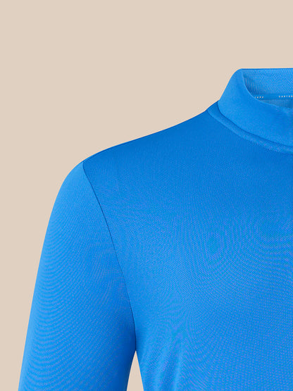 A close-up of a bright blue long-sleeve mock neck top, showing the ribbed texture of the fabric and the collar, set against a solid beige background.