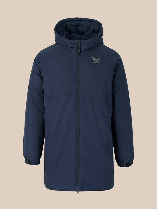 A navy blue hooded puffer jacket with a front zipper and a small gold winged logo on the left chest, displayed against a solid beige background.