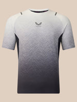 A short-sleeve athletic t-shirt with a white-to-black gradient and a subtle geometric line pattern. The brand logo 'Castore' is visible on the center chest, and 'Castore' is printed on the inner neck label.