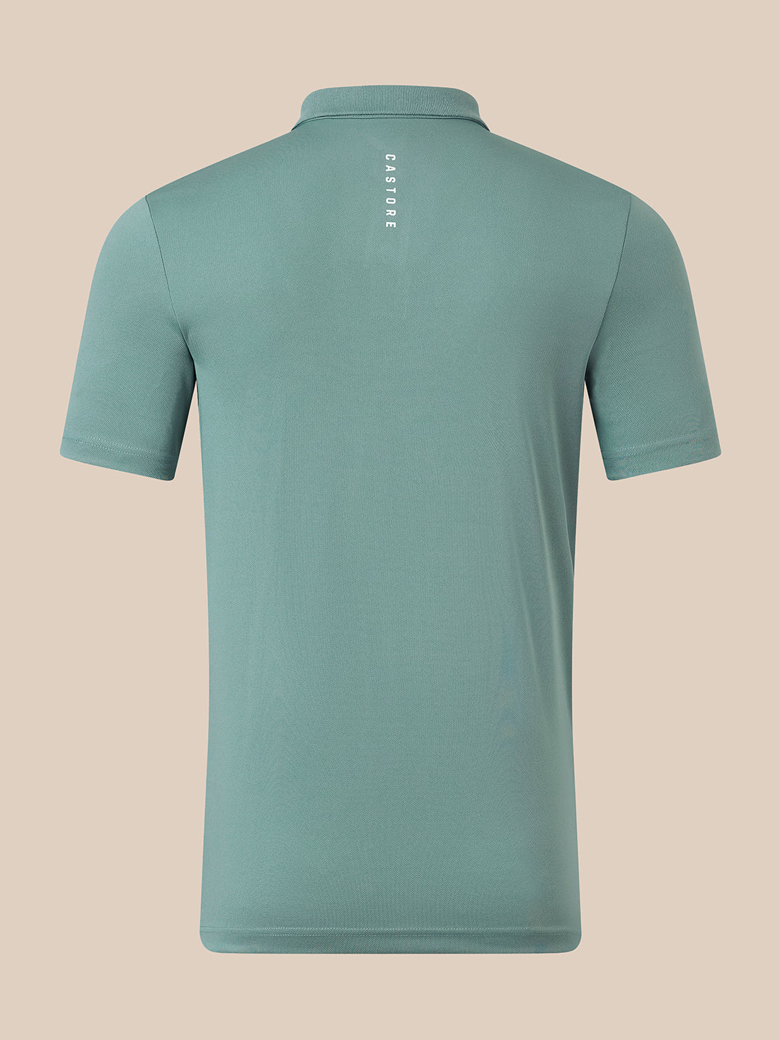 A short-sleeve polo shirt shown from the back, in a muted teal-green color with a small vertical white 'CASTORE' logo printed on the upper back, set against a solid beige background.