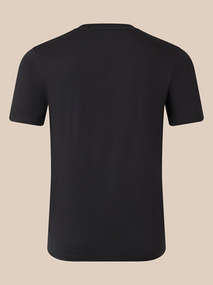 A plain black short-sleeve crewneck t-shirt shown from the back, displayed on a solid beige background.