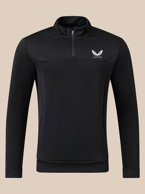 A black long-sleeve quarter-zip pullover with a small white winged logo and the brand name 'CASTORE' on the left chest, displayed on a solid beige background.