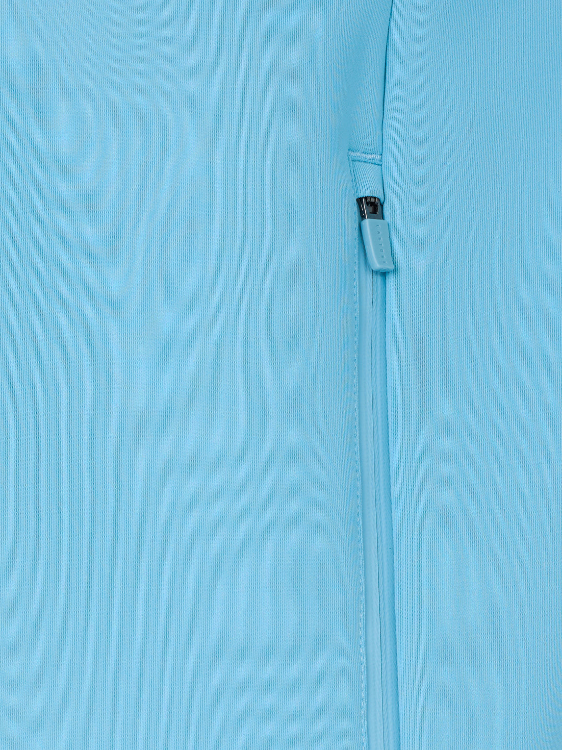 Close-up of a light blue fabric with a zipper on a matching background