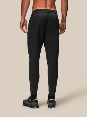 Back view of black men's Flex Joggers with elastic waistband and tapered cuffs.