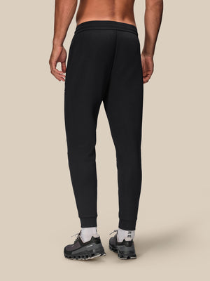 Back view of a male model wearing navy Flex Joggers with cuffed ankles