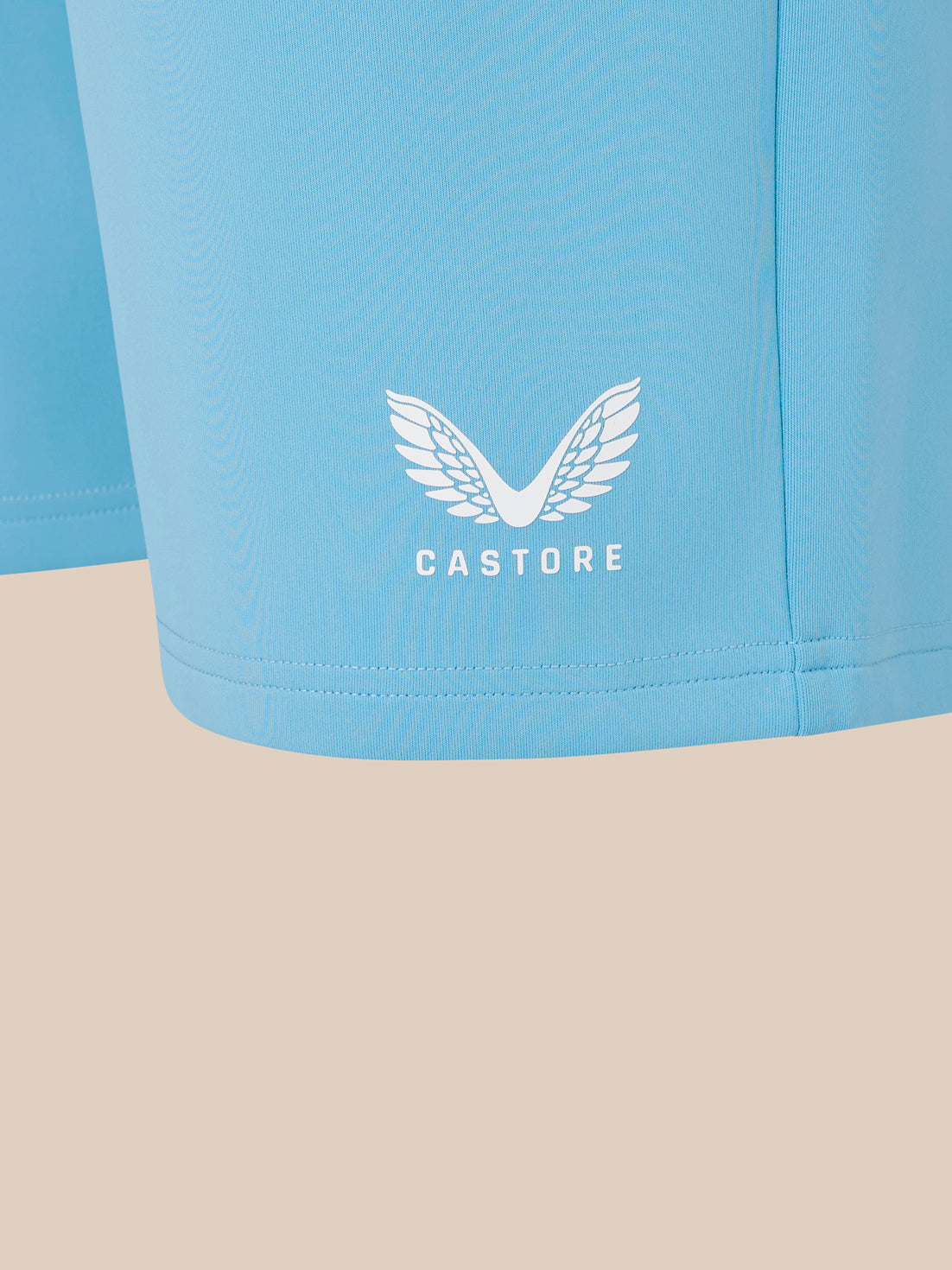 Light blue shorts with a white logo and text on a beige background