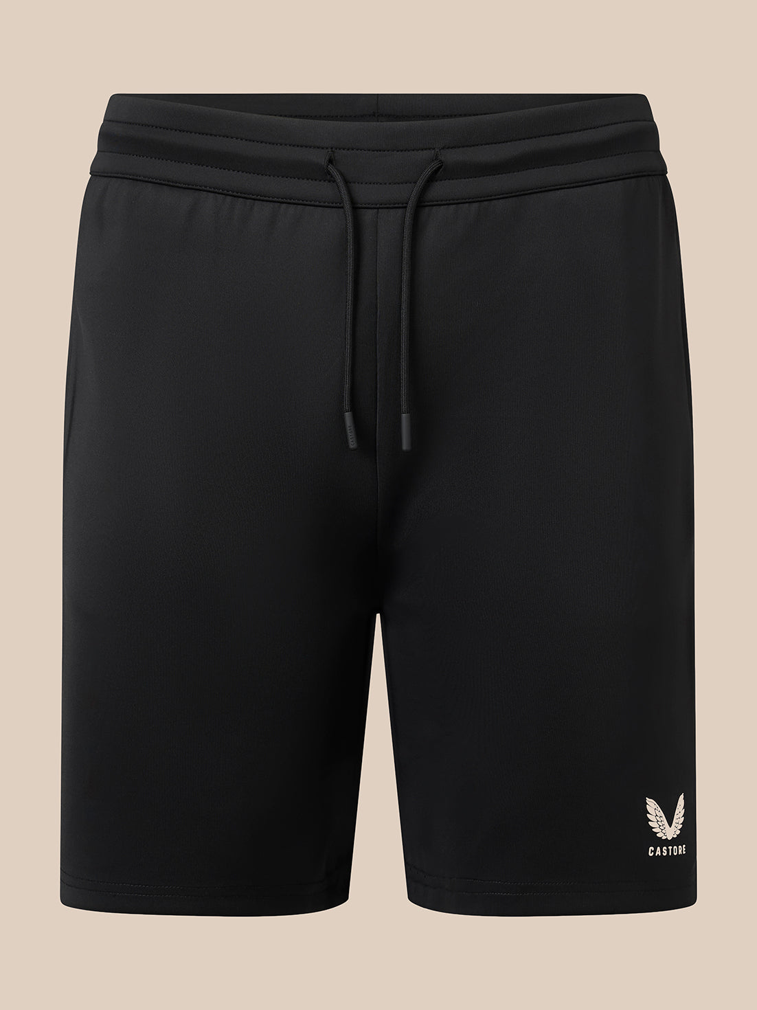 Black athletic shorts with a drawstring waistband and a small white embroidered logo on the lower left leg, shown against a solid beige background.