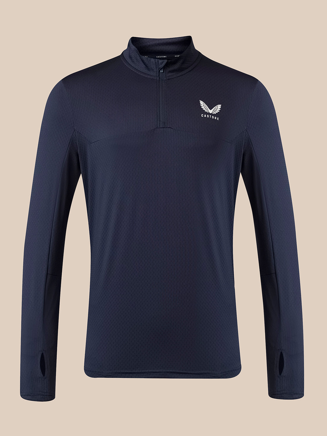 A navy blue long-sleeve quarter-zip athletic pullover with a white wing logo and the word 'Castore' on the left chest, displayed against a solid beige background.